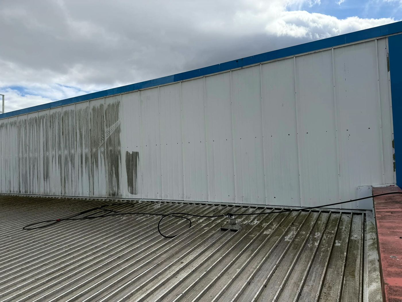 Rooftop cladding part-way through cleaning, with stained panels next to clean ones