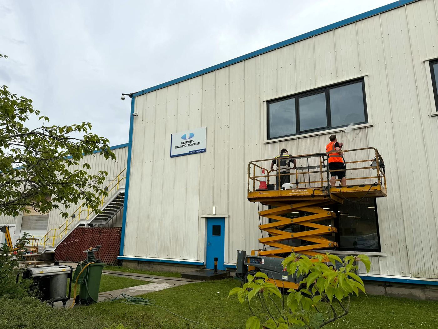 PropertyKleen team cleaning cladding from a scissor lift at Unipres Training Academy